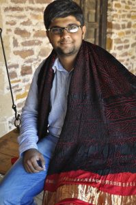 artist draped in cloth and smiling