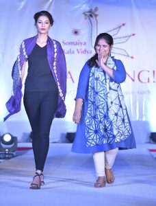 artist on the catwalk with model wearing artist's textiles