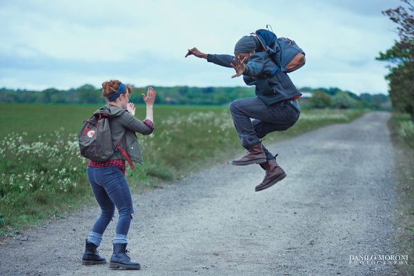 Two dancers in motion, one mid-clap and the other jumping in mid-air