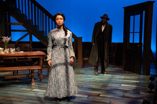 an actress in a historical costume stands on a theatrical stage