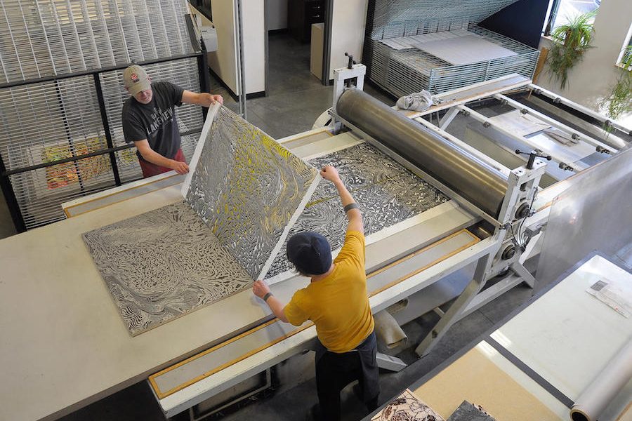 printmakers removing an overlay from a recent print