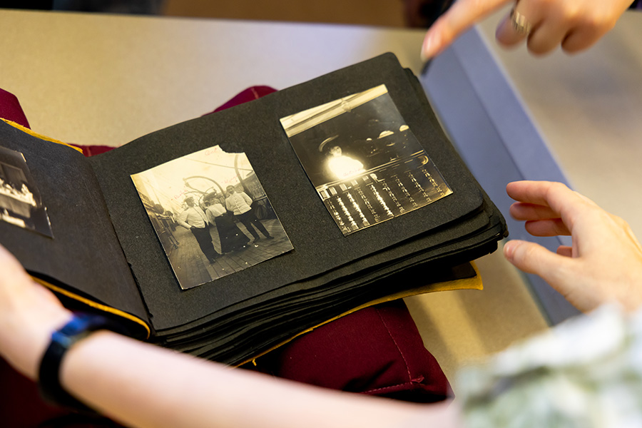 viewer holding open a photo album with sepia-toned images