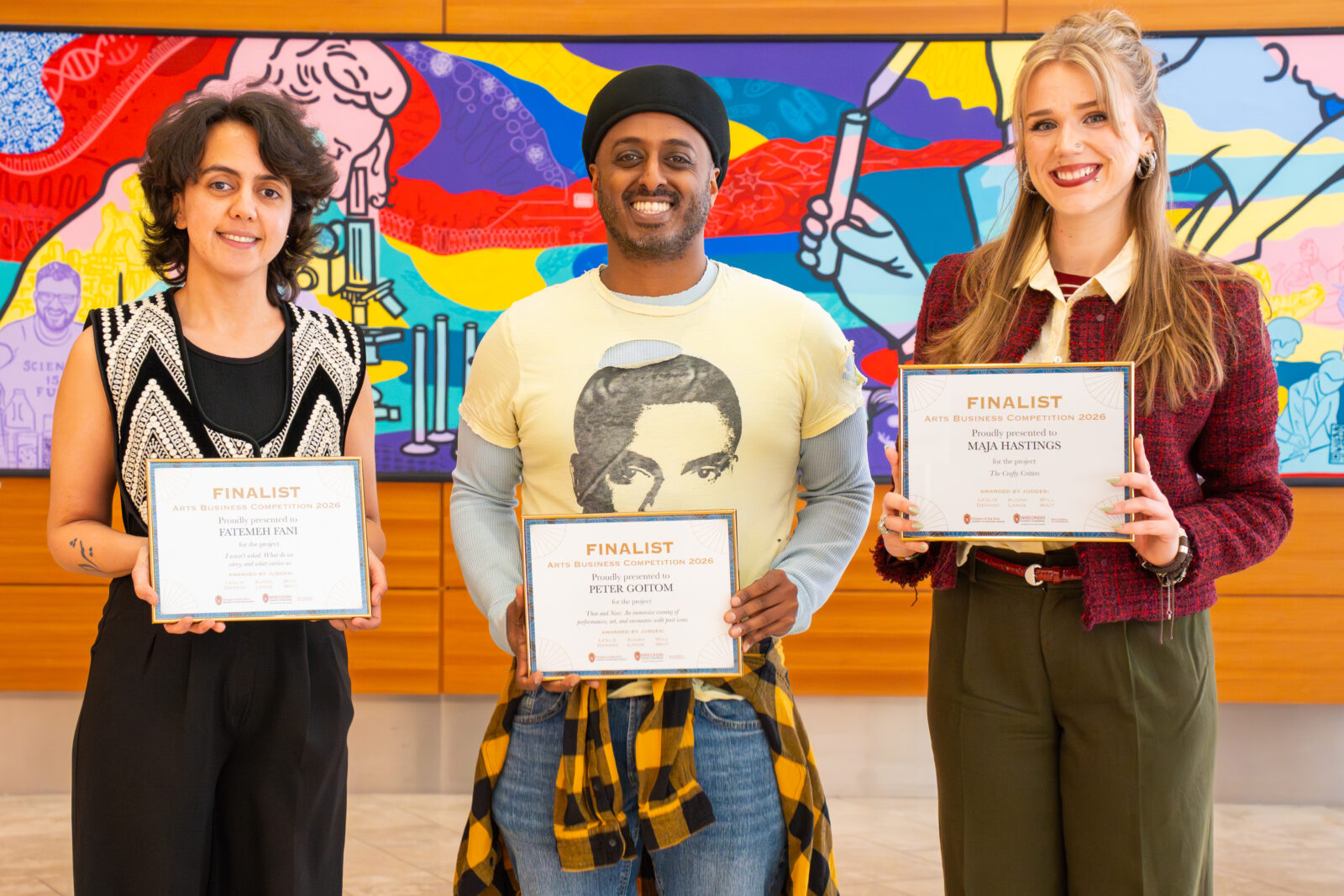 three smiling students holding award certificates