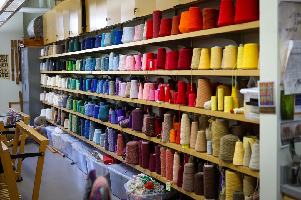 shelves lined with colorful spools of yarn