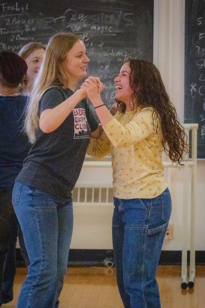 students partner dancing while laughing