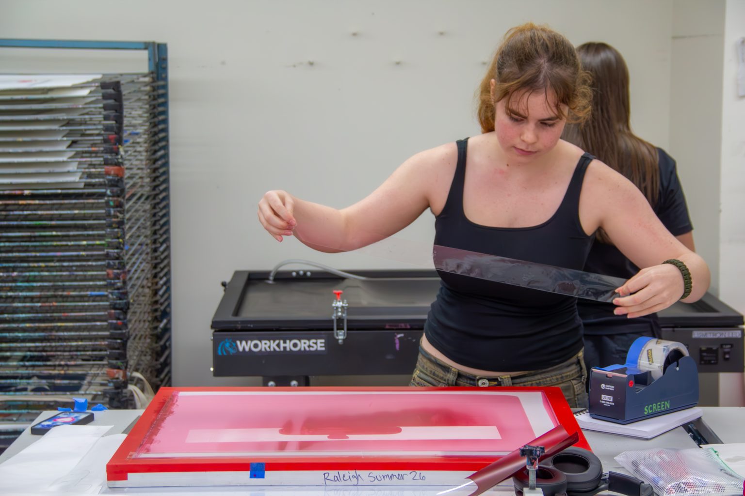 Raleigh Savage in the printmaking workshop setting tape for a print. Photo by Ted Hyngstrom