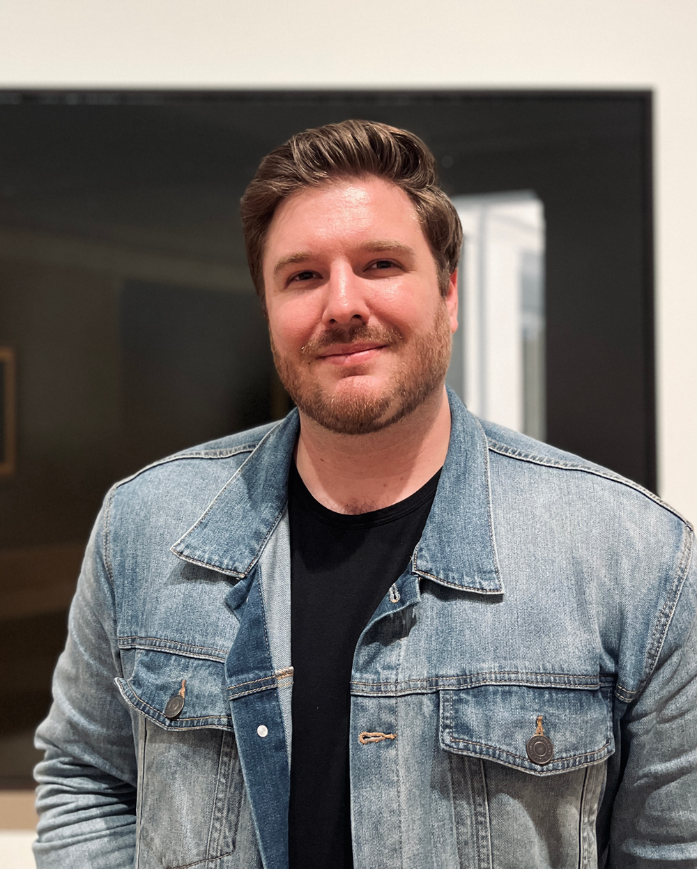smiling man wearing a denim jacket